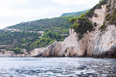 Scenic view of mountain by sea against sky