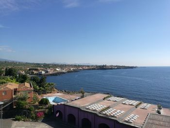 High angle view of townscape by sea against sky