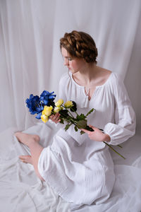 Ukrainian girl with blue yellow flowers in white