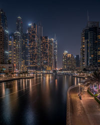 Illuminated buildings in city against sky at night