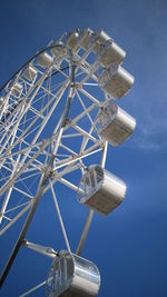 Low angle view of ferris wheel against blue sky