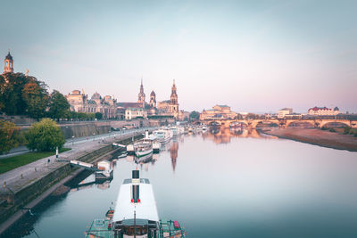 Boats in river with buildings in background