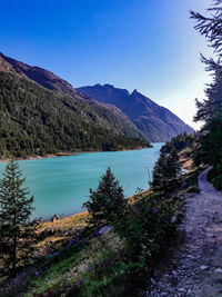 Scenic view of lake and mountains against blue sky