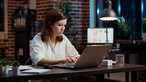 Businesswoman using laptop at table