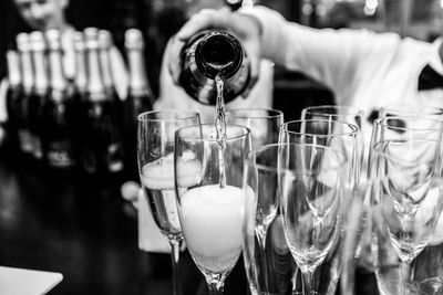 Bartender pouring alcohol in glass at counter