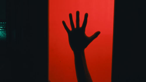Shadow of person gesturing against black background