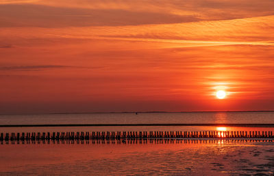 Scenic view of sea against orange sky