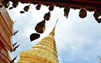 Low angle view of bells and wat phra that doi suthep against sky