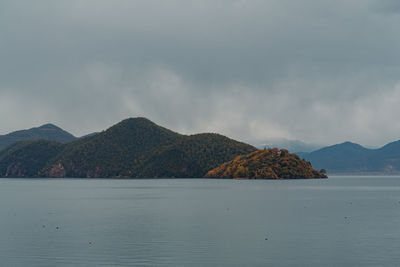 Scenic view of sea and mountains against sky