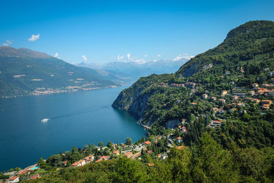 Aerial view of townscape by sea against sky