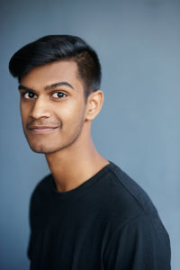 Portrait of young man against gray background