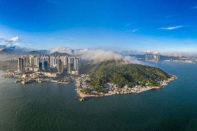 Panoramic view of city buildings against cloudy sky