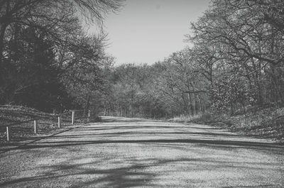 Road amidst trees against clear sky