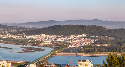 High angle view of townscape by river against sky