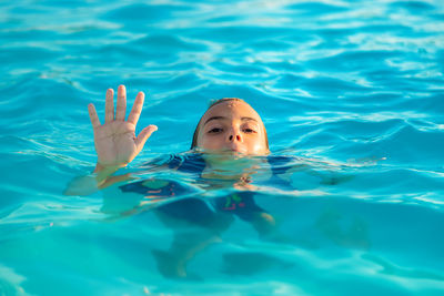 Cute girl drowning in swimming pool