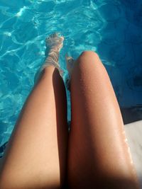 Low section of woman legs in swimming pool