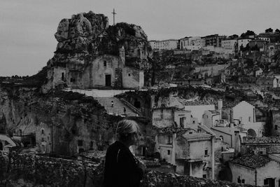 Side view of woman standing against cityscape