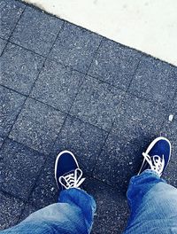 Low section of man standing on tiled floor