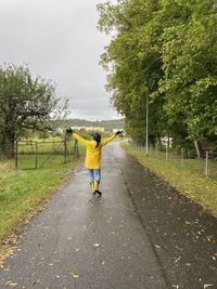 Rear view of man cycling on footpath