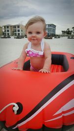 Portrait of cute smiling girl in boat against sky