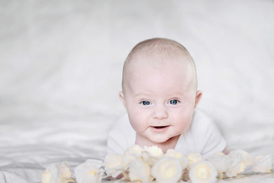 Close-up portrait of cute baby boy with decoration lying on bed