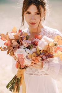 Portrait of young woman holding flower bouquet