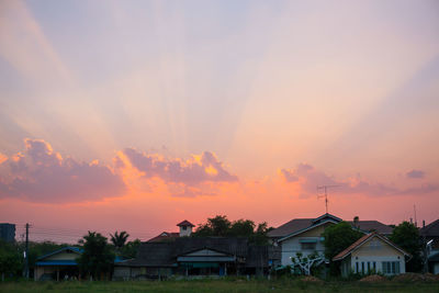 Houses and buildings against sky during sunset