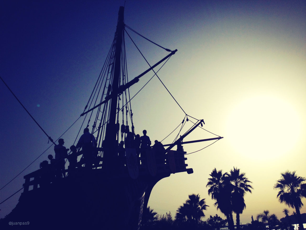 silhouette, clear sky, leisure activity, transportation, sunset, sun, lifestyles, low angle view, mode of transport, sunlight, men, sky, blue, travel, unrecognizable person, mast, outdoors, enjoyment, nautical vessel