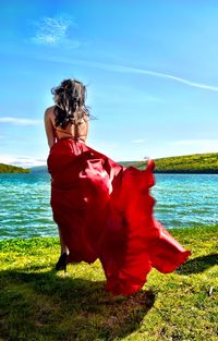 Rear view of woman on beach against sky