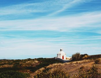 View of lighthouse amidst buildings against sky