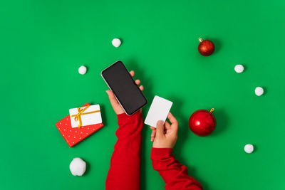Cropped hand of woman using calculator on table