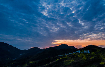 Scenic view of silhouette mountains against sky at sunset