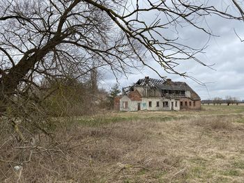 Abandoned house on field against sky