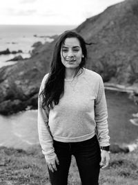 Portrait of young woman standing at beach