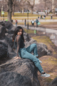 Portrait of woman sitting on rock