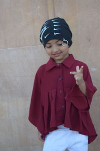 Portrait of smiling boy standing against wall