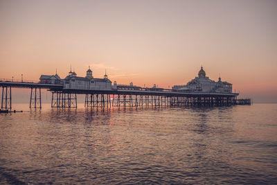 Eastbourne seafront at sunrise with calm sea and clear skies.
