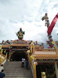 Statue against temple against sky