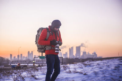 Photographer looking at his camera in front of city skyline