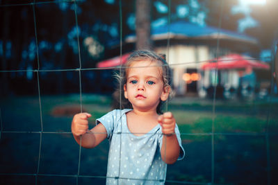 Cute girl looking through fence