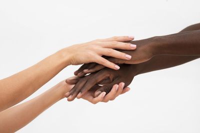 Women holding hands against white background