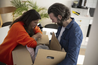 Mature couple searching in box while relocating at new home