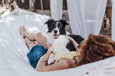 Woman with dog sitting on hammock