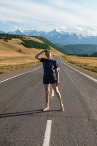 Full length of man skateboarding on road against sky