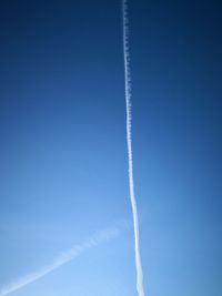 Low angle view of vapor trail against blue sky