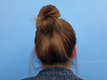 Rear view of woman against blue wall