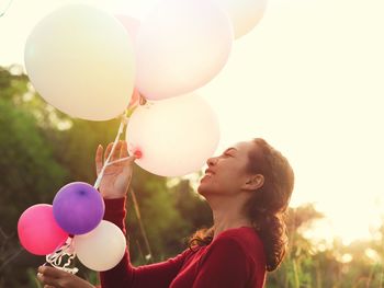 Low angle view of girl holding balloons