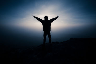 Silhouette man standing against sky at sunset