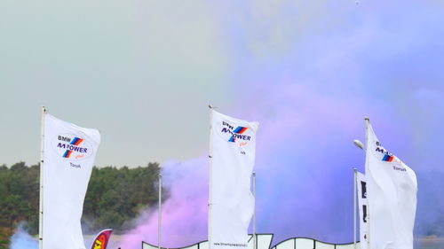 Low angle view of flags hanging on building against sky