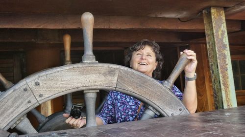 Smiling mature woman holding helm